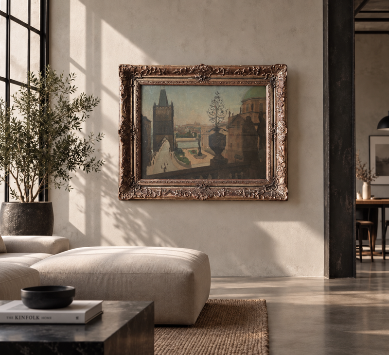 AI vizualizace: pražský obraz v ornamentálním rámu v moderním interiéru. Ilustrační prostředí, nikoli dokumentace stavu. AI interior visualization; not a condition photograph.